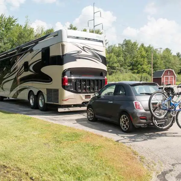 Motorhome using flat towing equipment for hauling a car